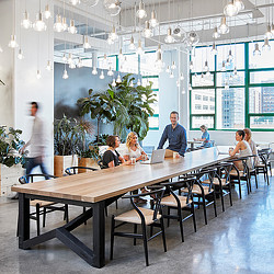 A group of people sitting at a table with laptops.
