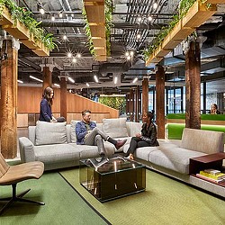 A group of people sitting on a couch in a large room.
