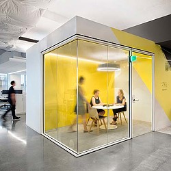 A glass walled room with a table and people in it.