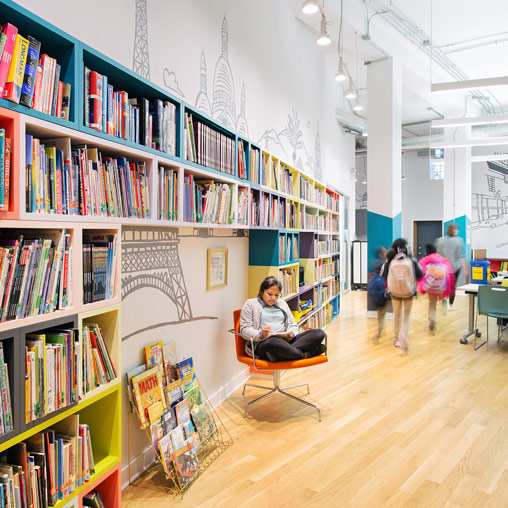 A person sitting in a chair in a library.