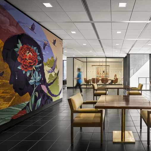 A room with a table chairs and a painting on the wall.