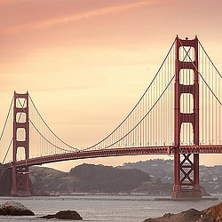 A large red bridge over water with Golden Gate Bridge in the background.