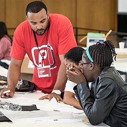 A group of people looking at a paper.
