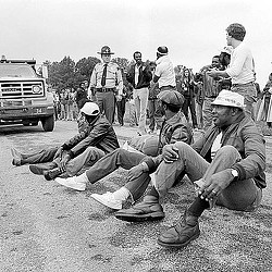 A group of men sitting on the ground.