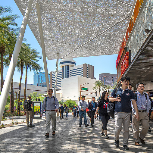A group of people walking on a sidewalk.
