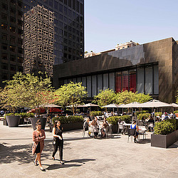 A couple of women walking in front of a building.