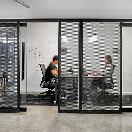 A couple of people sitting at a table in front of a glass door.