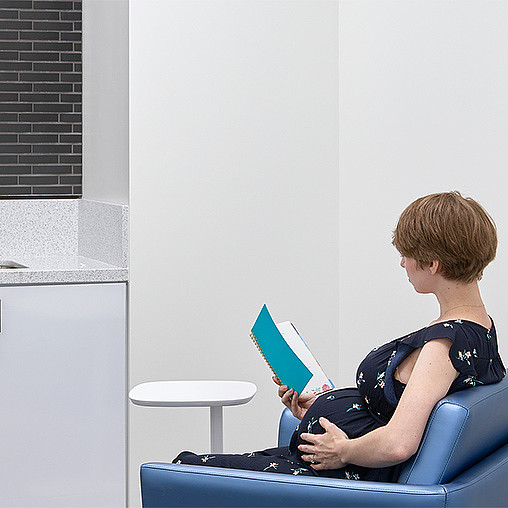 A person sitting on a chair reading a book.
