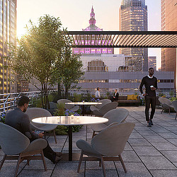 A person standing next to a table with a person sitting at it.