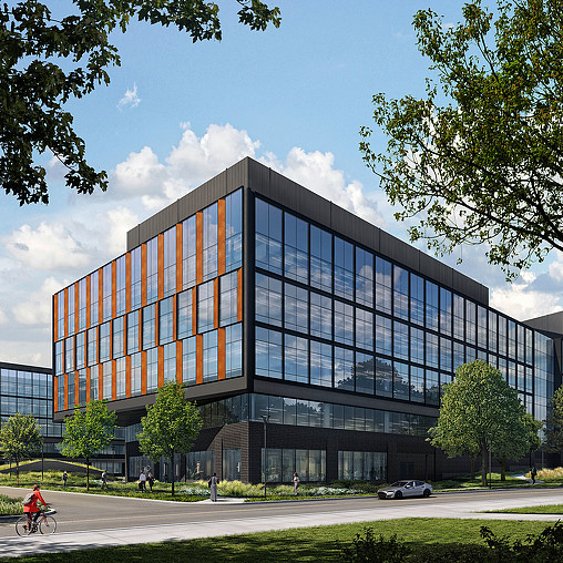 A large building with a person riding a bicycle in front of it.