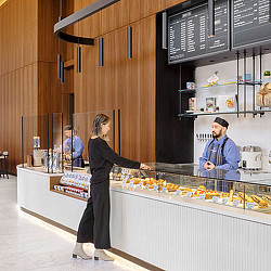 A person standing next to a counter with food on it.