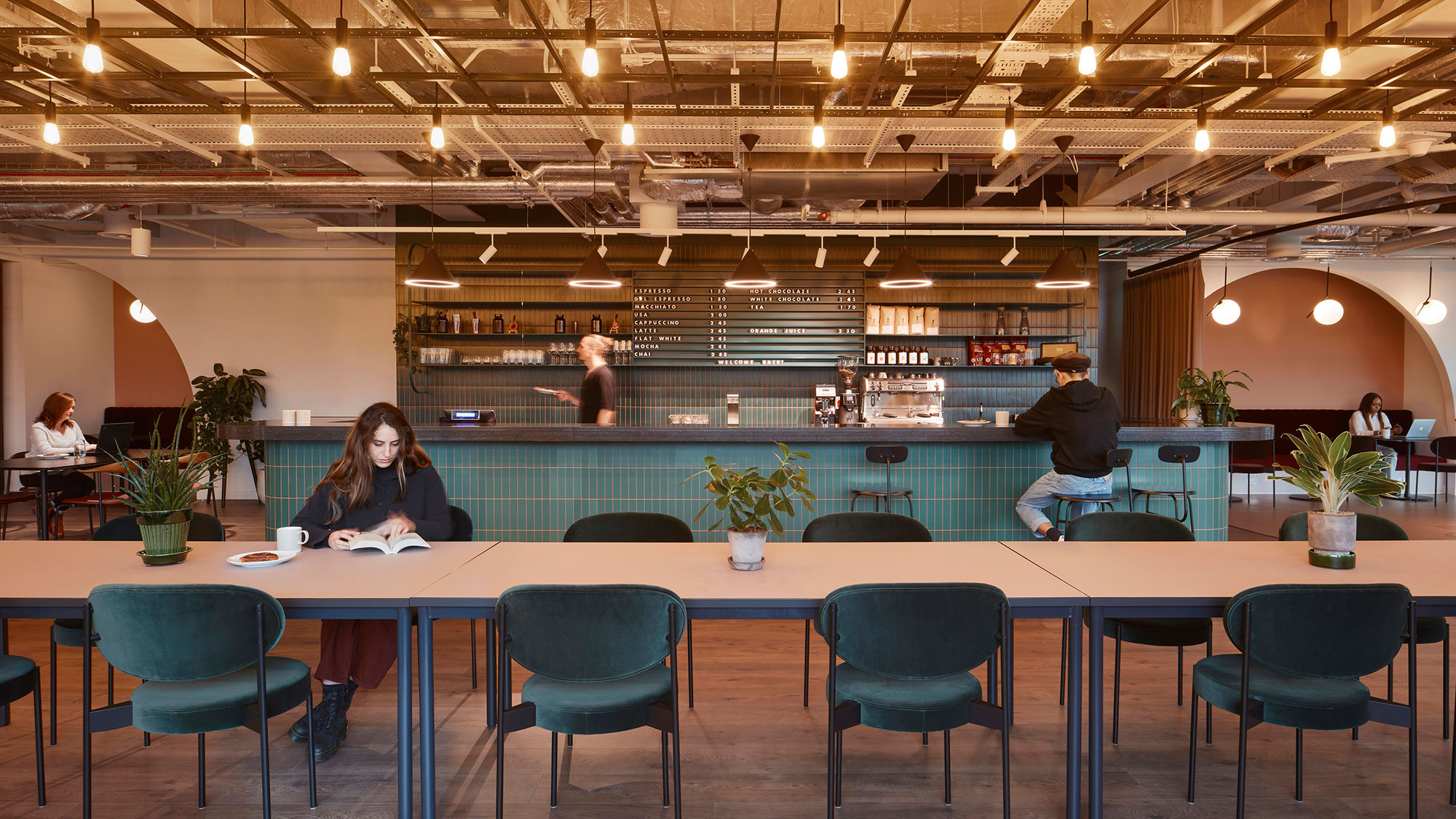 People working and eating at a work cafe and dining area.