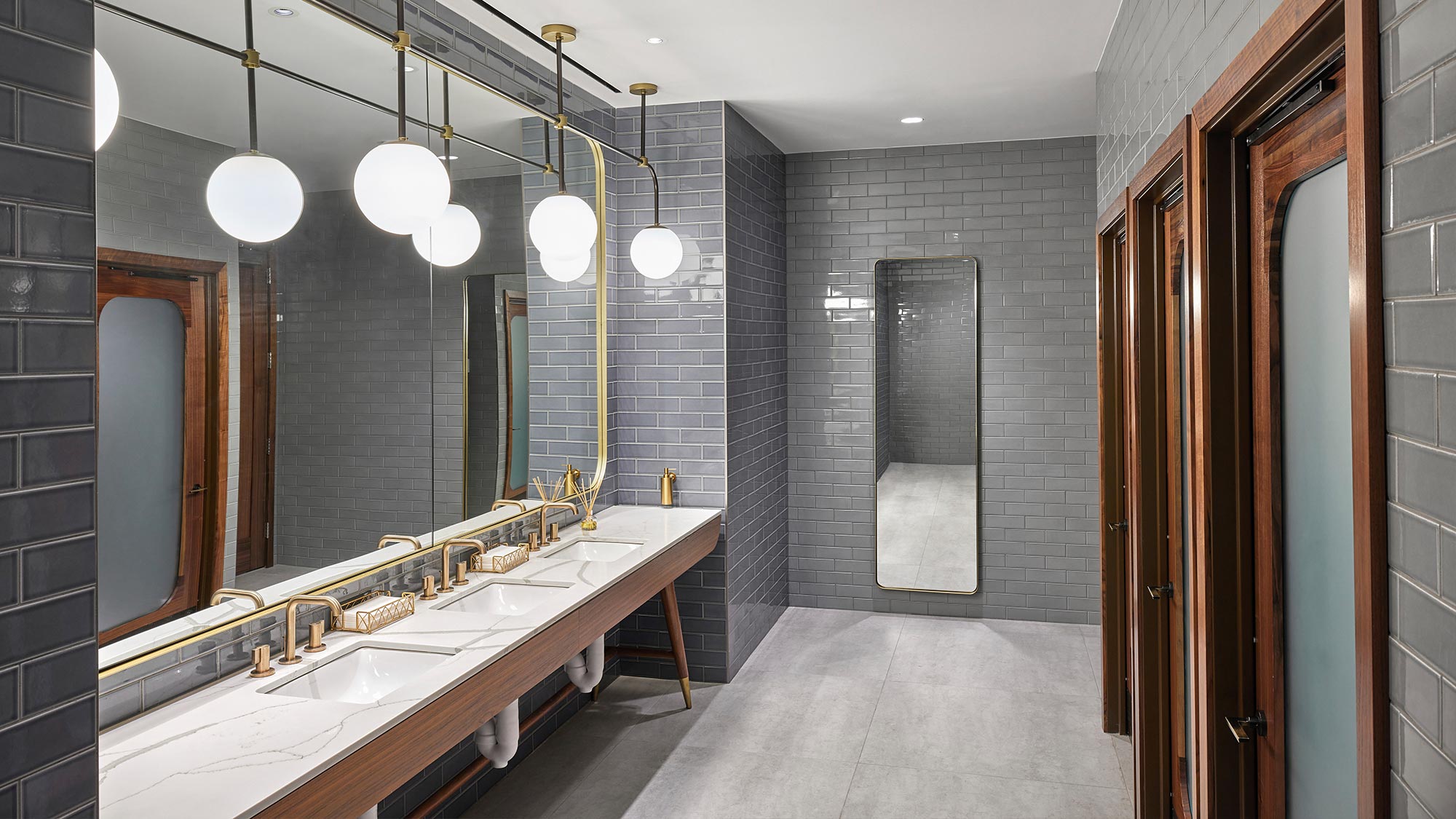 Guest bathroom at the Gensler-designed Watermark Hotel in Tysons, Virginia, with brass-tone basin faucets