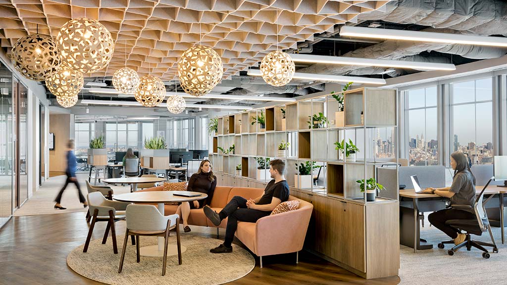 A group of people sitting at a table in a room with chandeliers.