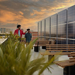 A couple of people standing in front of a building with glass windows.