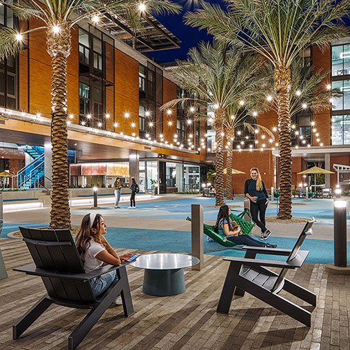 A person sitting on a bench next to a pool.
