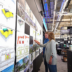 Two Gensler Houston employees reviewing a project on the wall
