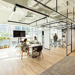 Gensler Singapore office open collaboration area with windows and plants