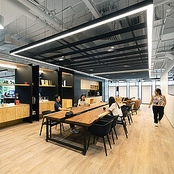 A group of people sitting at a table in a room with a ceiling.