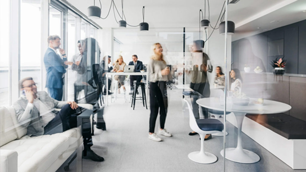 Employees mingling in office. Photo via Getty Images/Washingtonian.