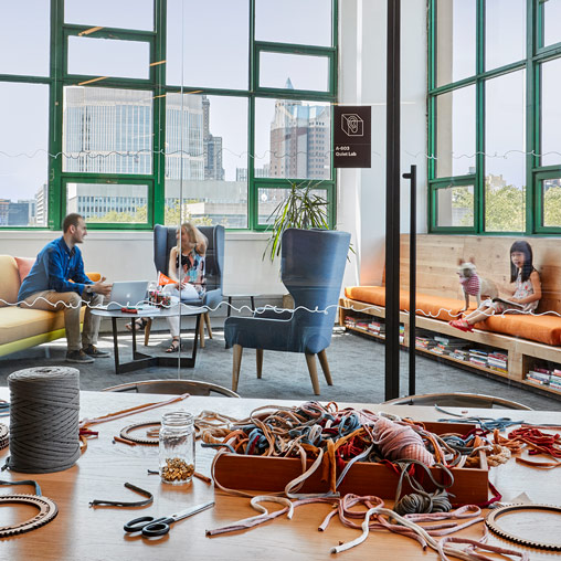 A group of people sitting in a room with a table and chairs.