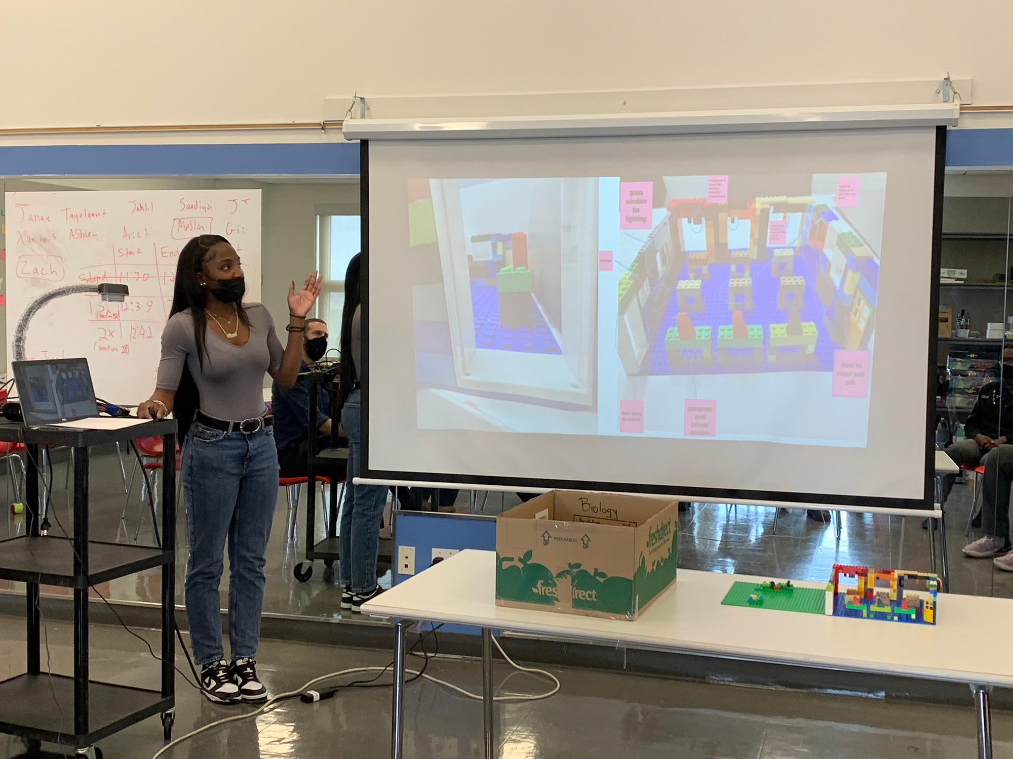 A person standing in front of a projector screen.