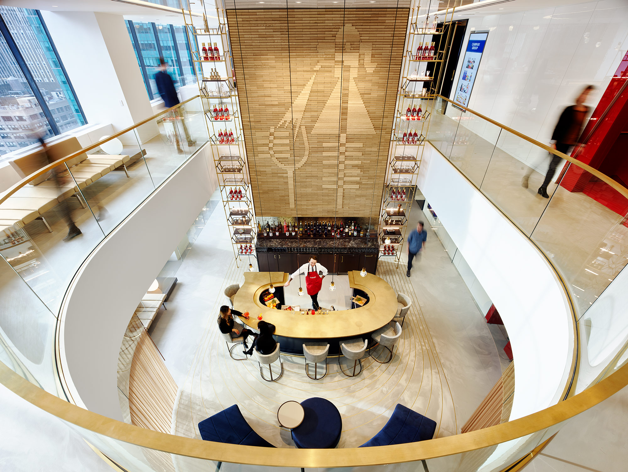 A high angle view of people sitting at a bar in a double-height room.