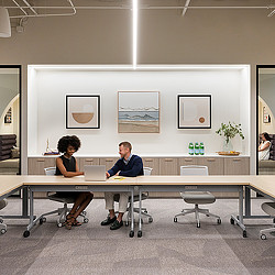 A man and woman conversing in workplace conference room