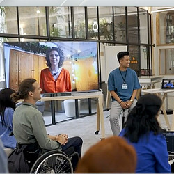 A person in a wheelchair talking to a group of people.