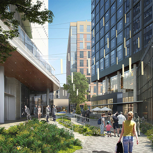 People walking on a sidewalk between buildings.