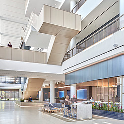 An indoor atrium with seating and an open staircase at a financial services firm