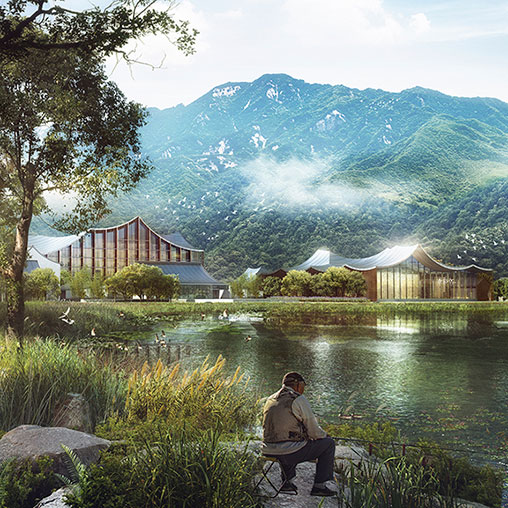 A person sitting on a bench by a lake with mountains in the background.