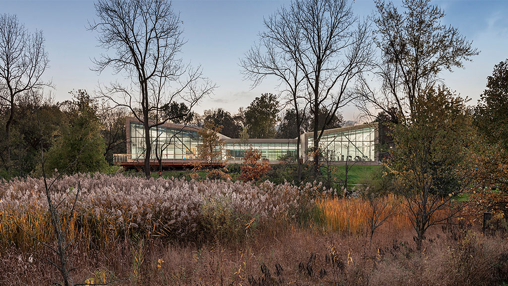 A building with trees and bushes in front of it.