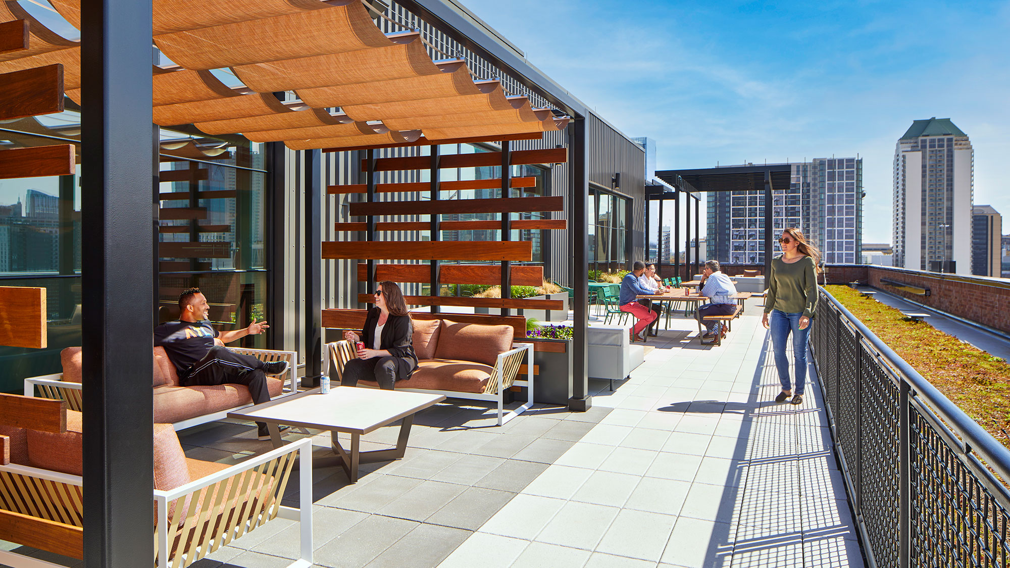 A group of people sitting on a patio with a building in the background.