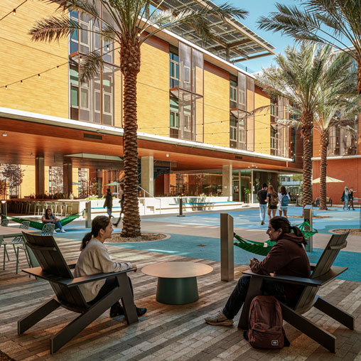 A couple of people sitting on a bench in front of a building.