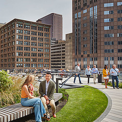 A man and woman sitting on a bench in front of a building.