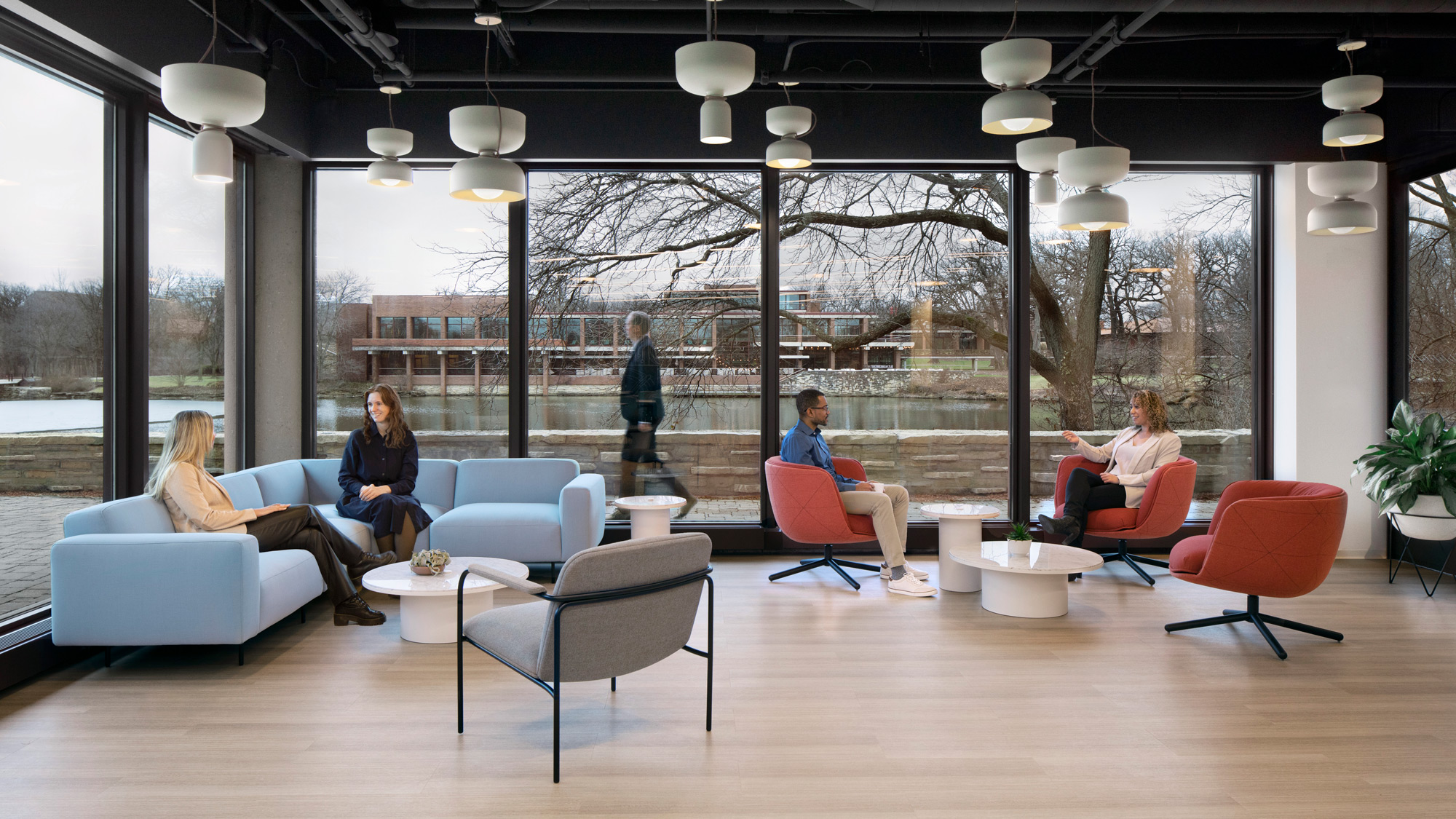 A group of people sitting in chairs in a room with a large window.