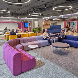 A group of people sitting in a room with purple couches at Virtru headquarters