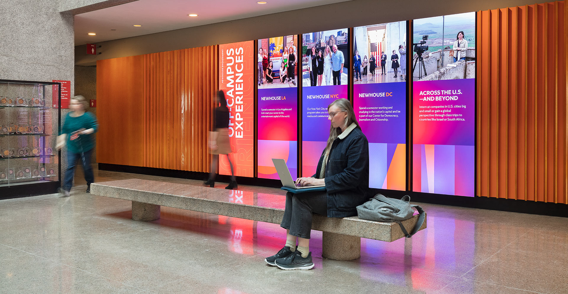 A person sitting on a bench with a laptop.