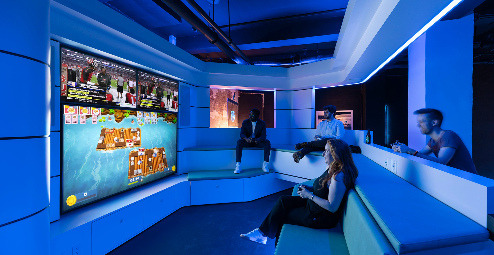 A group of people sitting on a bench in a room with blue walls.