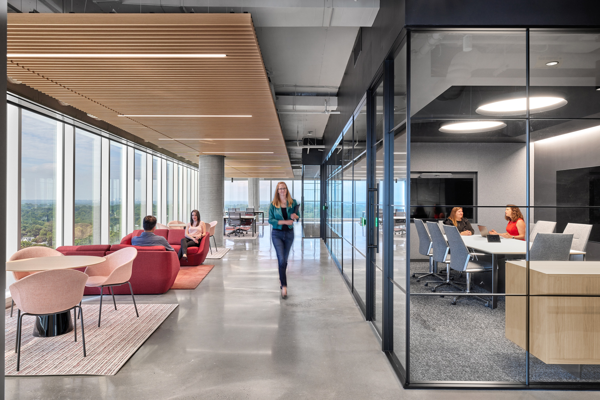 A person walking in a room with people sitting at tables.