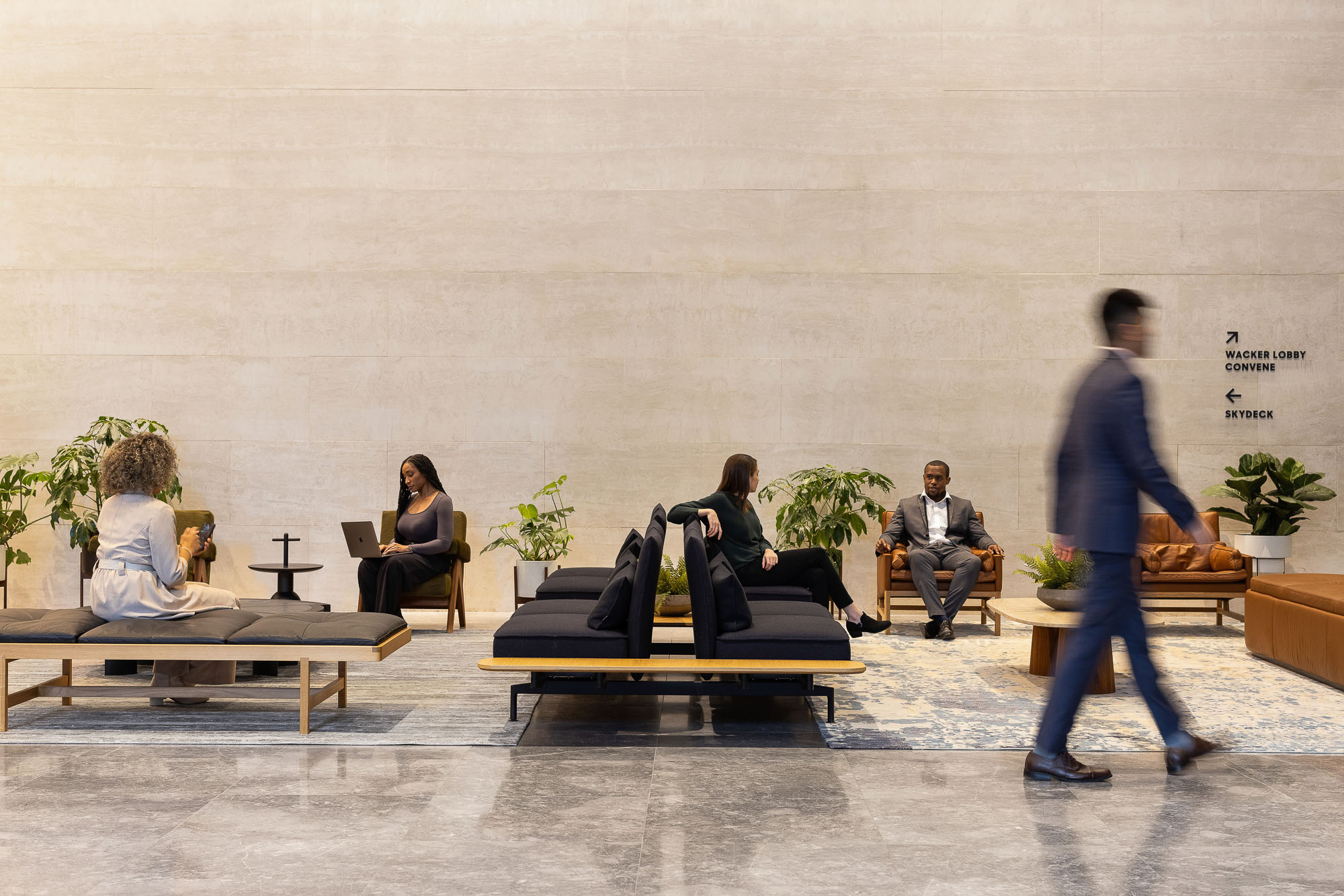 A person walking past a group of people sitting on benches.