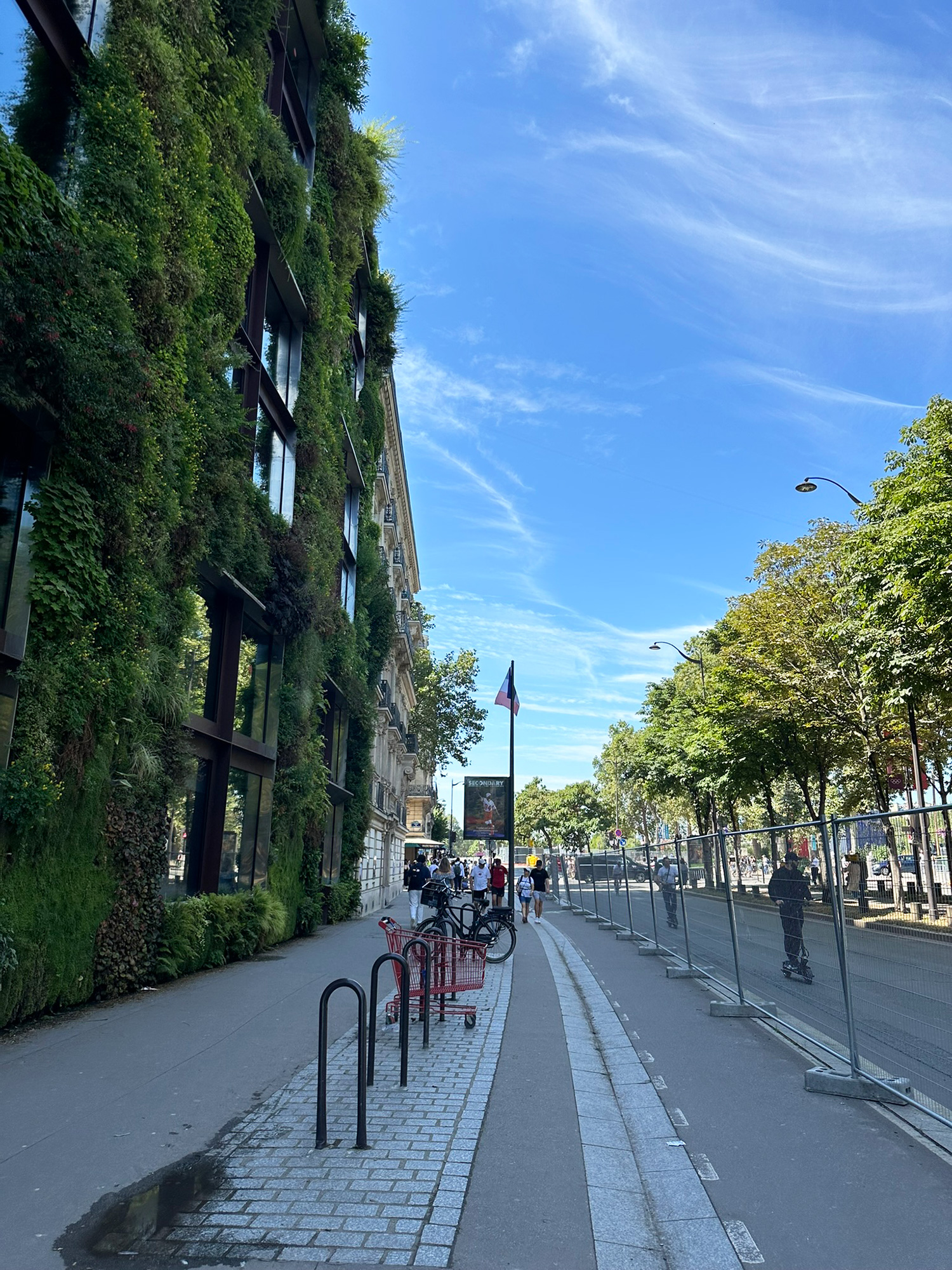 A group of people riding bikes down a sidewalk.