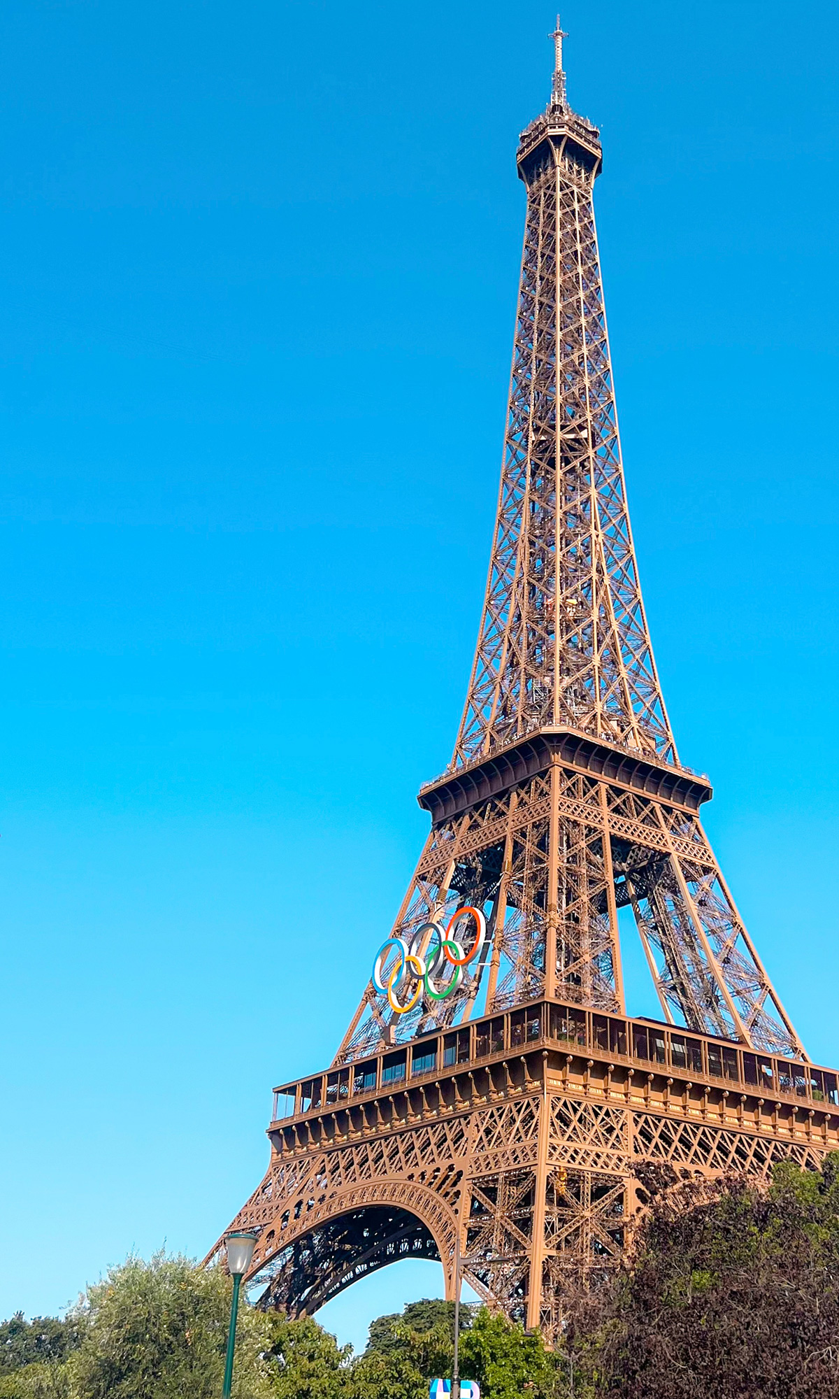 A tall metal tower with Eiffel Tower in the background.