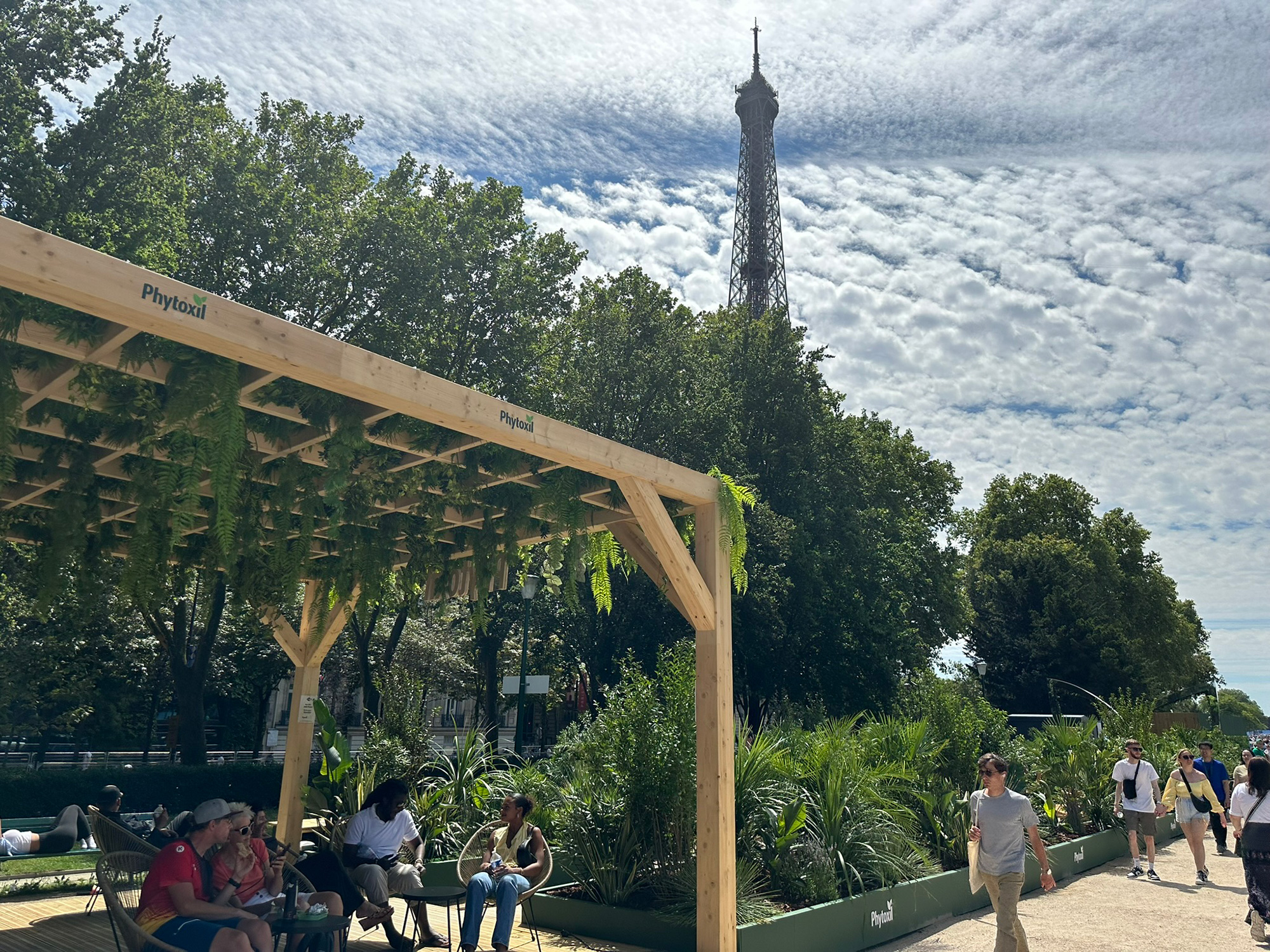 A group of people sitting on a bench in front of a tall tower.