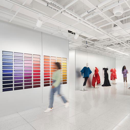 A group of people walking in a large room with white walls.