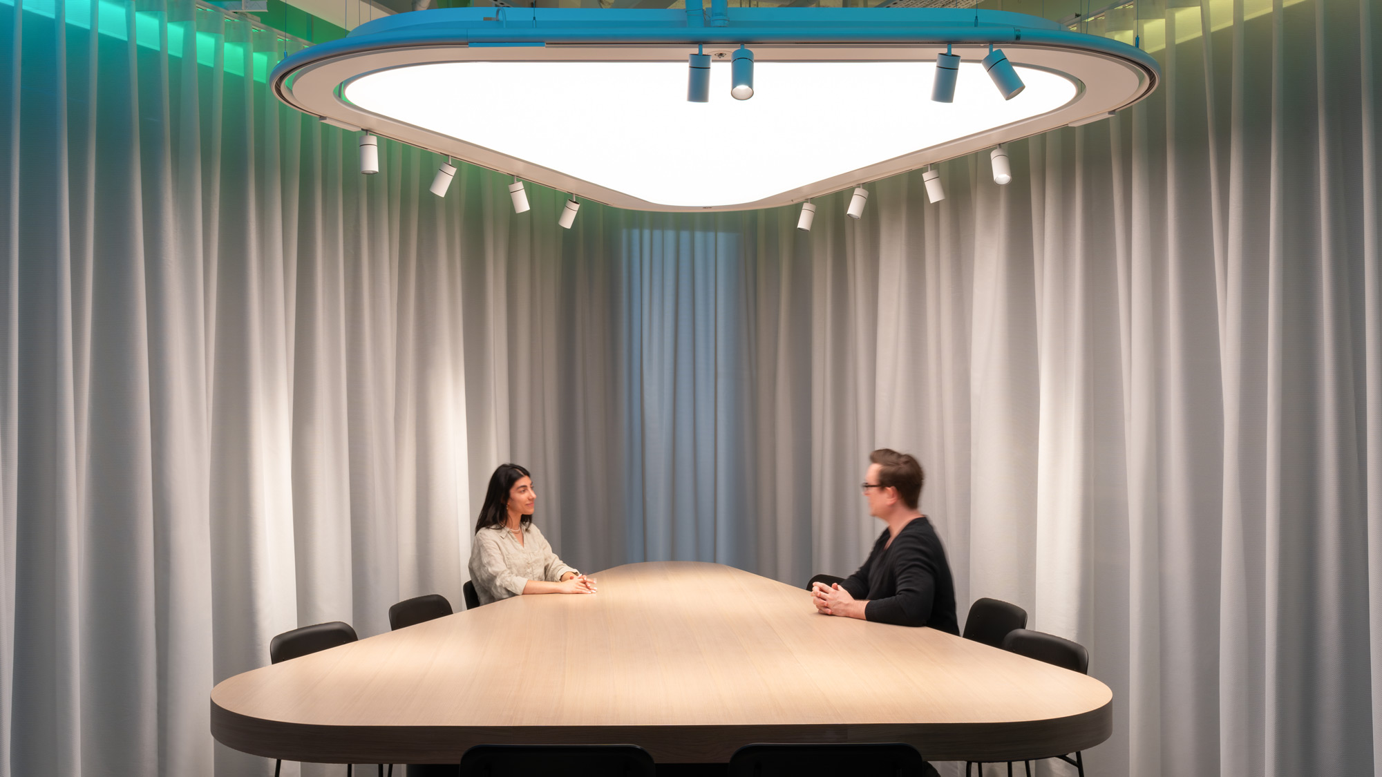 A man and a woman sitting at a table with a white tablecloth.
