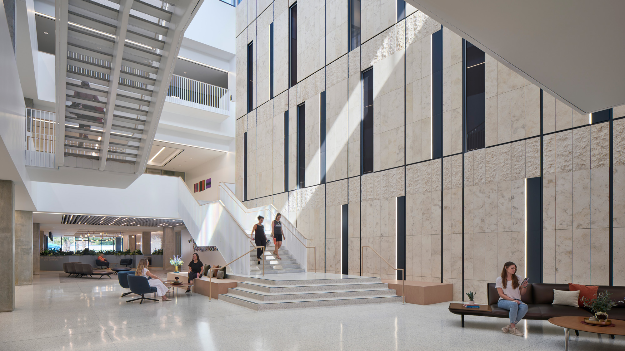 A person sitting on a bench in a large building.