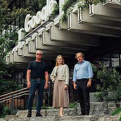 A group of people standing on a porch in front of a house.