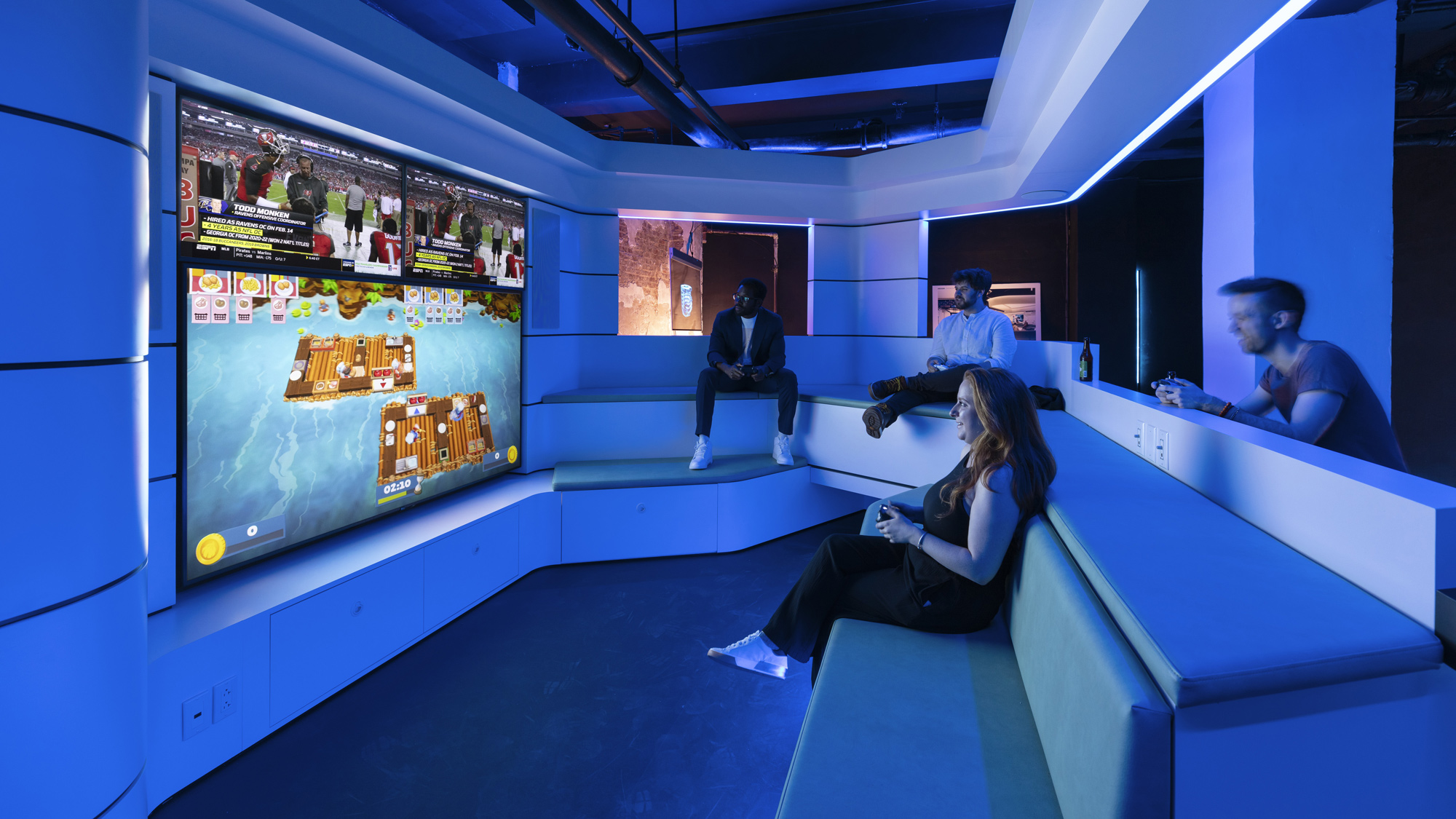 A group of people sitting on a bench in a room with blue walls.